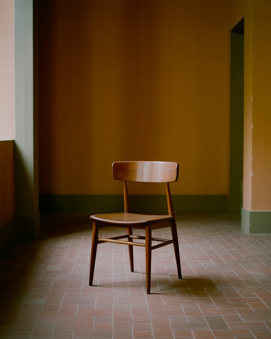 Una silla de madera vacía en un cuarto cálido y despejado